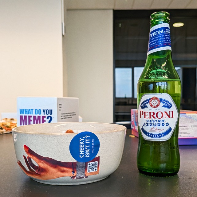 A stickered Peroni beside a 'What do you meme?' box
