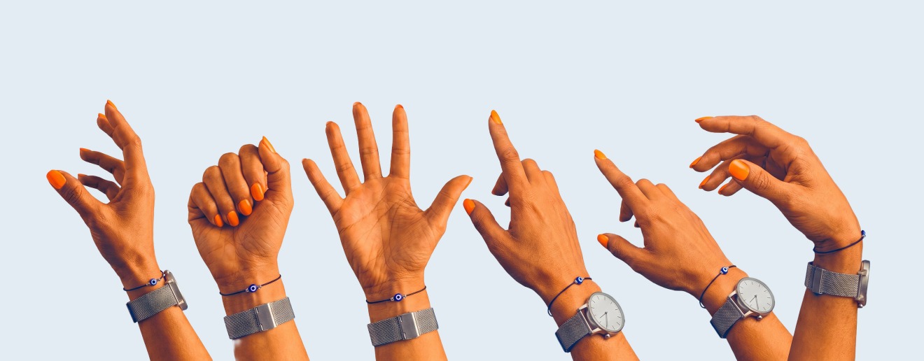 The campaign hand - orange nail, 'Cheeky, isn't it?' wristband - shown in several poses