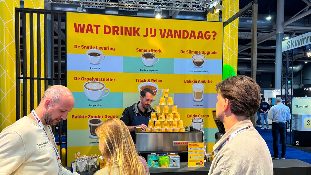 The DHL stand at Webwinkel Vakdagen, visitors at the coffee bar under the “Wat drink jij vandaag?” menu